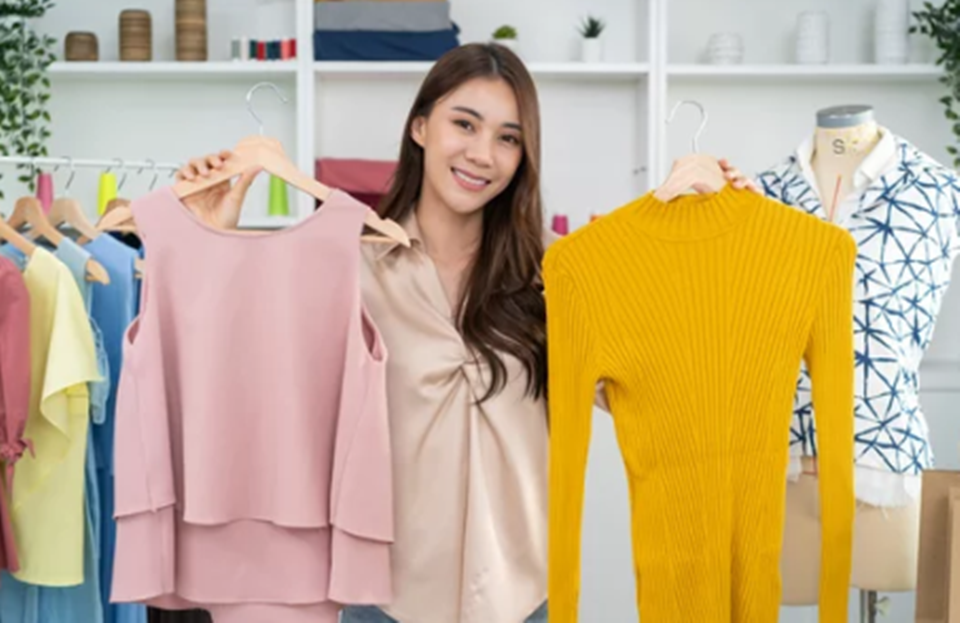 両手にアパレル商品をかざす女性