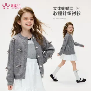 グレーのカーディガンと白いスカートの女の子