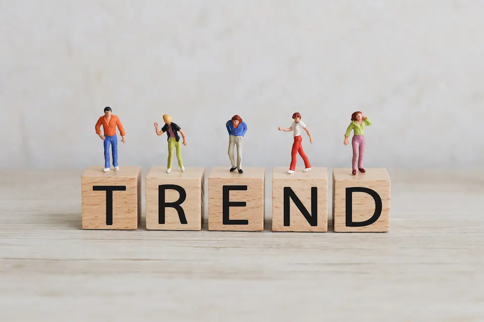 積み木にTRENDの文字、その上にたつ男女5人