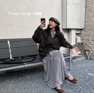 スマホ片手にベンチに座る女性