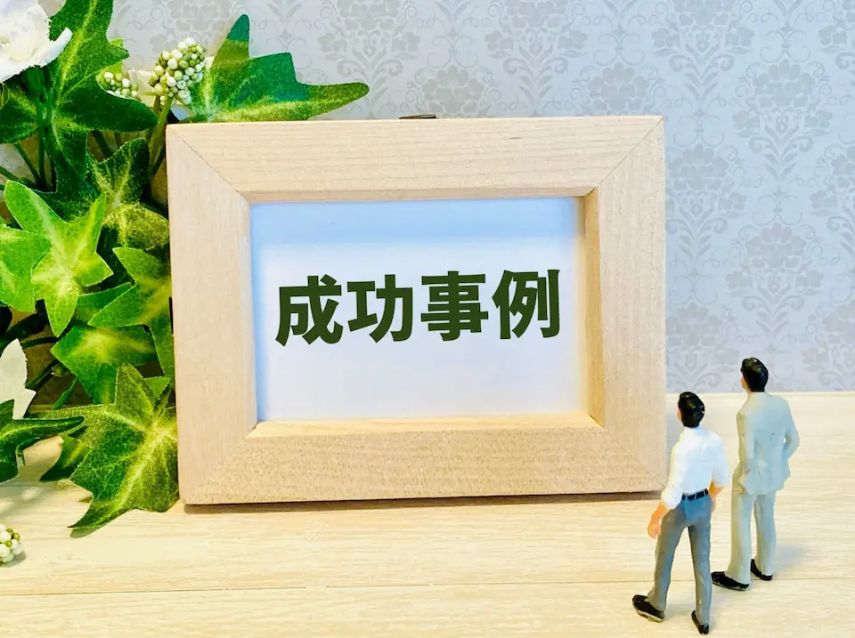 成功事例の文字を見るビジネスマン二人