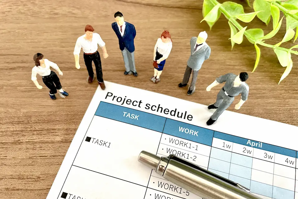PROJECT SCHEDULEの前にたつ6人のビジネスパーソン