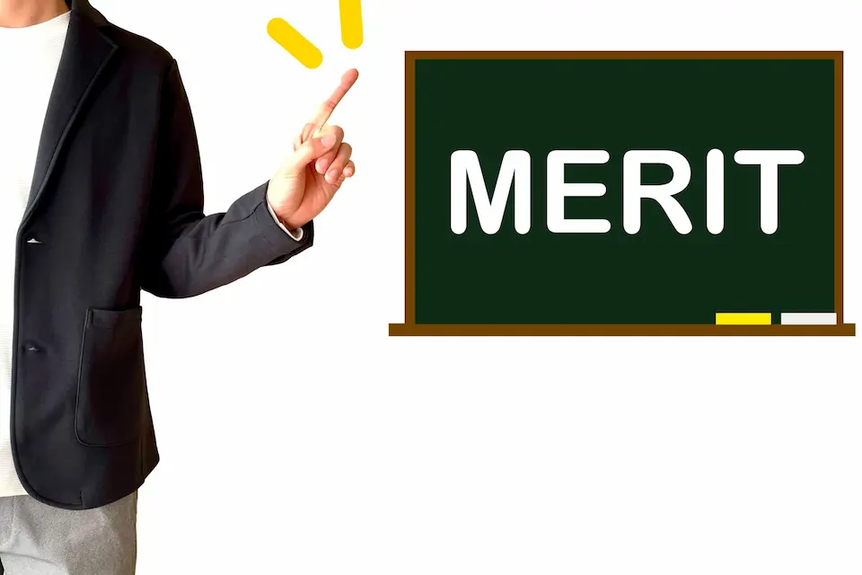 黒板にMERITの文字と、それを指さす男性