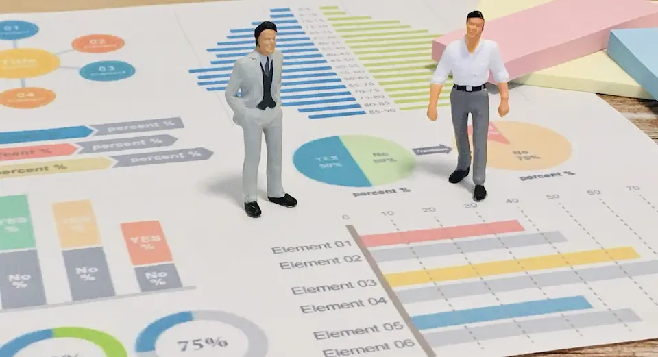 販売データの上に立つ二人のビジネスマン