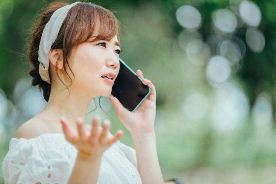 携帯電話で苦情を伝える女性