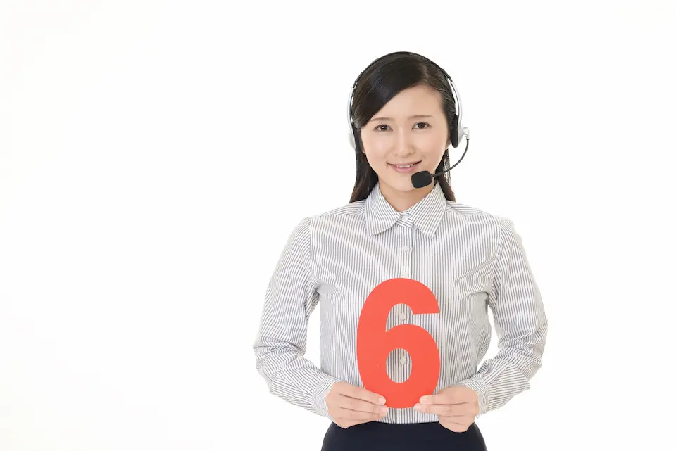 数字の6を両手でもつ女性