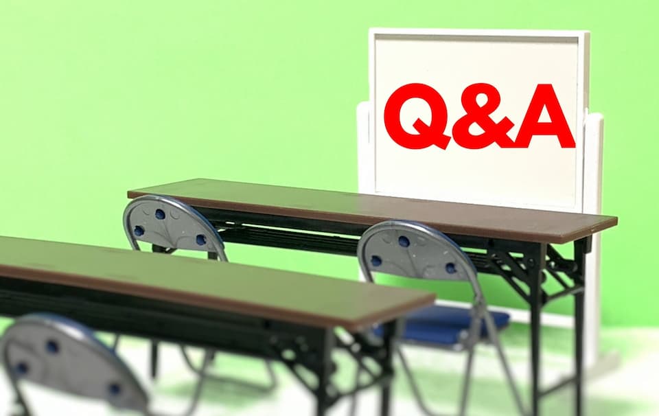 Ｑ＆Aが書かれた白版と机・椅子のイラスト