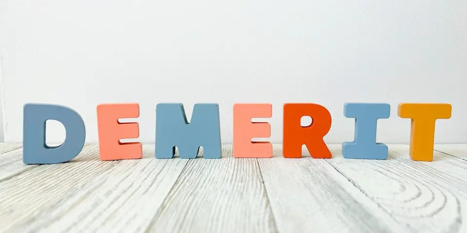 床に立つDEMERITの文字